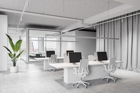 Spacious open office with sleek desks, chairs, and computers, featuring large windows and a plant. Modern business concept. 3D Renderingの写真素材
