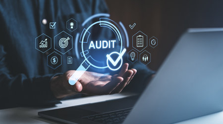 Person showing digital audit icons including checklist and analytics, against a dark background, representing quality control conceptの写真素材