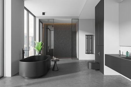 Black and white hotel bathroom interior with bathtub, glass shower, sink and wall hung toilet. Panoramic window on Kuala Lumpur skyscrapers. 3D renderingの写真素材