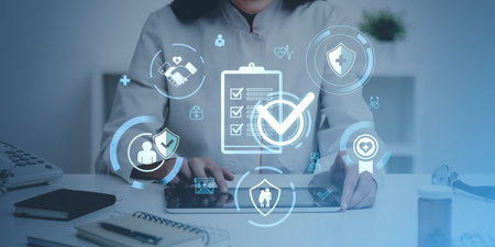 Doctor using tablet with health insurance icons floating. Blue overlay. Concept of medical treatment and insurance benefitsの写真素材