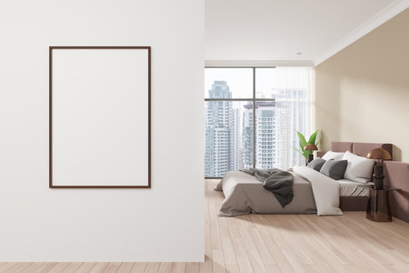 Empty poster frame on a wall in a modern bedroom setting. Large windows reveal a cityscape. Clean, minimalist interior. 3D Renderingの写真素材