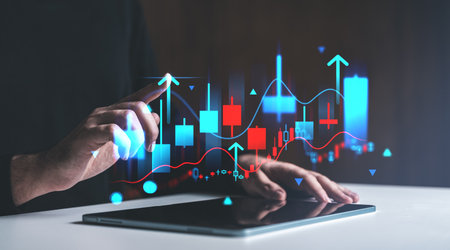 Hand interacts with digital financial chart on tablet, glowing graphics on dark background, concept of stock market analysisの写真素材