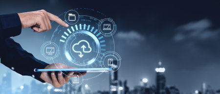 Hand pointing at a digital cloud storage interface on a tablet, with file icons surrounding it. Futuristic technology concept, cityscape backgroundの写真素材