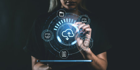 Person using a tablet with holographic cloud storage icons. Graphic interface with file and device symbols. Concept of global digital storageの写真素材