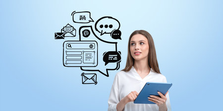 Woman holding tablet with communication icons on light blue background, depicting digital interaction and messaging conceptの写真素材