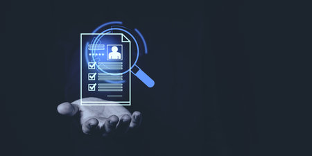 A glowing digital resume held by a hand with a magnifying glass on dark background. Concept of recruitment, job application, and candidate screeningの写真素材