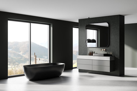 A modern bathroom with black bathtub, minimalist vanity, large mirror, and mountain view from wide windows. Concept of luxury home interior. 3D Renderingの写真素材