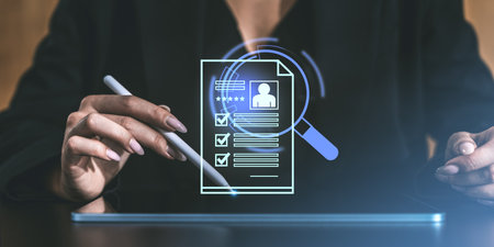 A person holding a stylus while interacting with a digital resume displayed as a hologram. Corporate setting with a focus on recruiting and evaluationの写真素材
