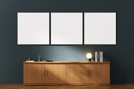 Three blank canvases hanging on a dark-colored wall above a wooden cabinet in a modern, minimalist room setting. 3D Renderingの写真素材