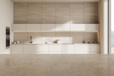 A stone countertop in the foreground with a modern kitchen interior blurred in the background. Ideal for product display or presentation. 3D Renderingの写真素材