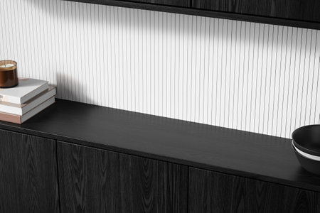 Minimalistic black wooden countertop with a candle, stacked books, and bowls, against a white vertical lined background. Concept of interior design. 3D Renderingの写真素材