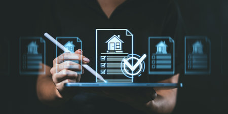 A person using a stylus on a tablet with a digital house checklist icon overlay, on a dark background. Concept of digital real estate managementの写真素材
