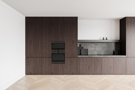 Dark wood kitchen cabinets with a speckled stone backsplash and built-in appliances on a light chevron floor, creating a minimalist, sleek interior design concept. 3D Rendering.の写真素材