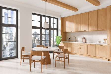 Spacious modern kitchen interior featuring wooden cabinets, a round dining table with chairs, and large windows with city views in natural light. Home decor. 3D Rendering.の写真素材