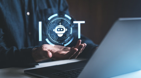Holographic robot icon representing IoT concept, floating above human hands near a laptop, on a...
