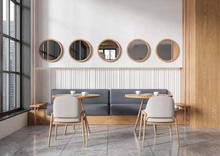 A modern cafe interior with round mirrors, wooden furniture, and large windows. Minimalist design with neutral tones and cozy seating. Concept of stylish eatery. 3D Rendering.の写真素材