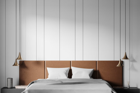 Cozy bedroom setup with brown upholstered headboard, white bedding, golden pendant lights, and white panel walls. Modern, minimalist interior concept. 3D Rendering.の写真素材
