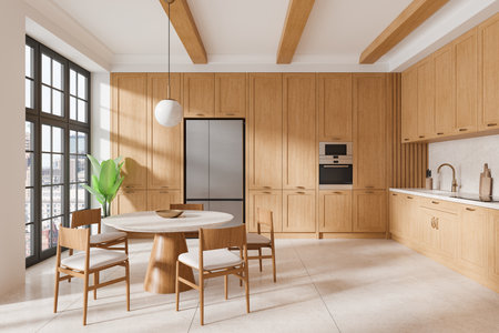 Modern kitchen with wooden cabinets, round dining table, and chairs in a sunlit room with large windows. Light, clean, and minimalist home interior concept. 3D Rendering.の写真素材