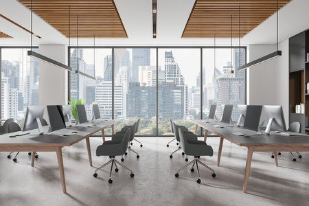 Open space office with sleek furniture, large desks, and panoramic windows. Cityscape view in the background. Concept of modern coworking interior. 3D Rendering.の写真素材