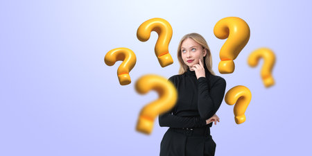 Thoughtful woman surrounded by yellow question marks, wearing black outfit, soft gradient background, concept of curiosityの写真素材