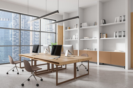 Modern office interior with wooden desks, ergonomic chairs, large windows showcasing a city view, and organized shelving. Concept of coworking space. 3D Rendering.の写真素材