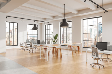 Bright open office interior featuring large windows, wooden floors, desks, chairs, stools, greenery, and natural light. Concept of modern workspace. 3D Rendering.の写真素材