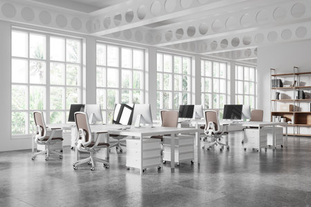Bright coworking office interior with modern desks, ergonomic chairs, and large windows. Tropical greenery outside. Concept of modern workspace. 3D Rendering.の写真素材
