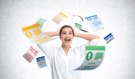 Excited woman surrounded by colorful floating resumes, white background, concept of HR, hiring challenges, job applicationsの写真素材
