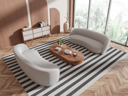 Stylish living room with curved white sofas, striped rug, wooden coffee table, light wood flooring, and large windows overlooking greenery. 3D Renderingの写真素材