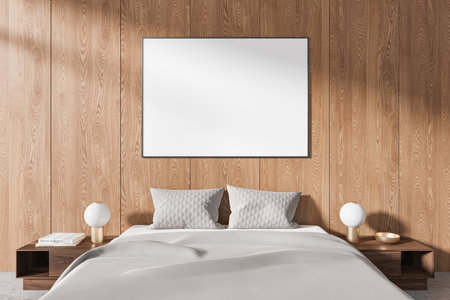 A blank poster displayed in a cozy bedroom with a wooden panel wall, modern bedding, and stylish side tables. Elegant interior design concept. 3D Rendering.の写真素材