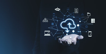 Hand holding a glowing cloud icon surrounded by technology symbols on a dark background. Represents online storage, networking, and remote dataの写真素材