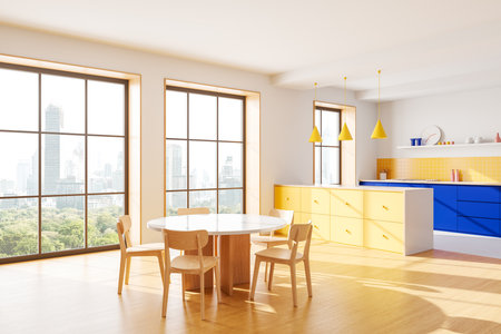 Bright modern kitchen interior with yellow and blue cabinets, wooden dining table, and large windows showcasing a cityscape. Contemporary design concept. 3D Rendering.の写真素材