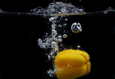 yellow paprika makes bubbles, isolated black backgroundの写真素材