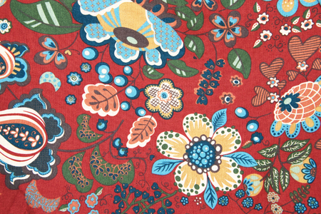 abric pattern with classical image of the colorful flowers on red background.