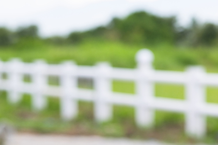 white fence in farm field. image is blurred and filteredの写真素材