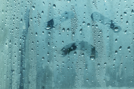 Natural water drop on glass with sadly face hand drawの写真素材