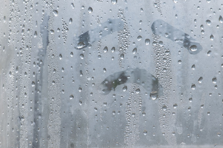 Natural water drop on glass with sadly face hand drawの写真素材