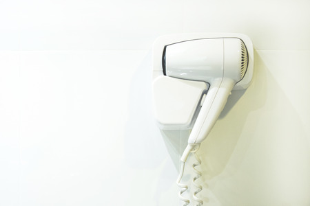 White Hair Dryer on wall in in hotel room.の写真素材