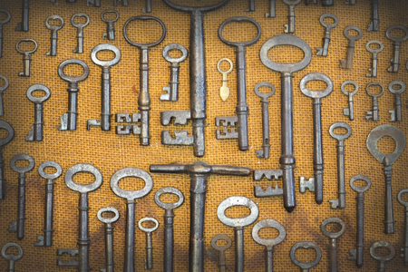 overhead of many different retro keys on brown sack fabric background concept.の写真素材