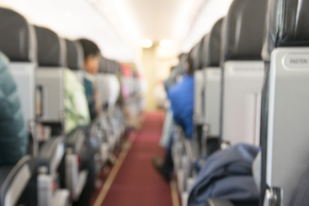 Defocused view at passengers seating in the airplaneの写真素材