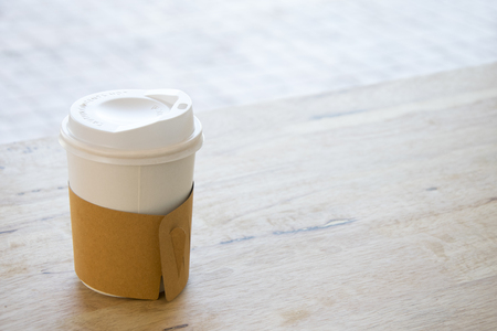 Hot coffee in paper cup isolated on wood table background. with copy spaceの写真素材