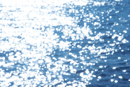 Reflection light on blue sea defocused abstract lights.の写真素材