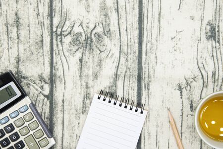 notebook calculator pencil and tea on wooden background. top view, flat lay concept.の写真素材