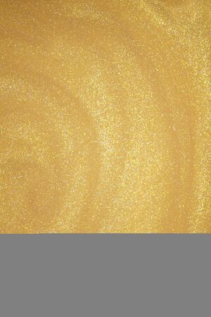 Golden glitter dust on dark background.の写真素材