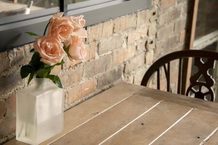 Pink Roses in a vase on a table in a restaurantの写真素材
