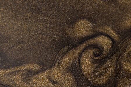 Golden glitter dust on dark background.の写真素材