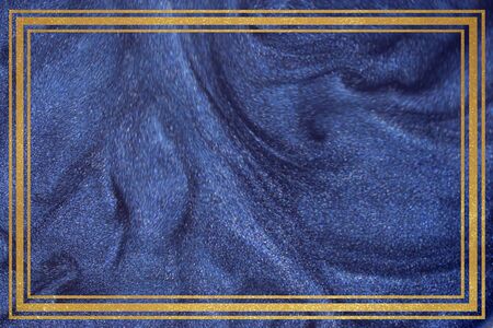 Golden frame on glitter dust dark blue background.の写真素材