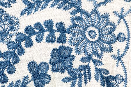 Embroidered blue flowers on a white background.の写真素材