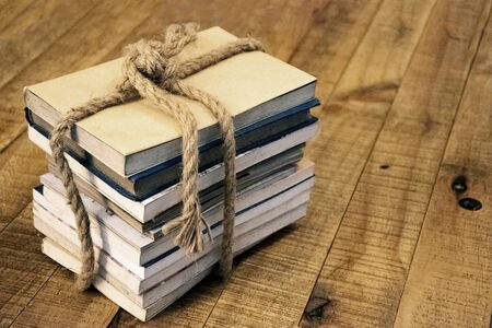 Old book tied with a thick rope on a wooden tableの写真素材