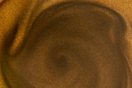 Golden glitter dust on dark background.の写真素材